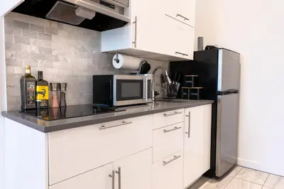 a kitchen with white cabinets and a refrigerator at #4 - Quaint Studio - Self Check in - Plateau - St-Denis - AC - TV in Montréal
