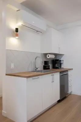 a kitchen with white cabinets and a sink at #5 - Spacious 3Bds - Self Check in - Plateau - St-Denis - AC - TV in Montréal