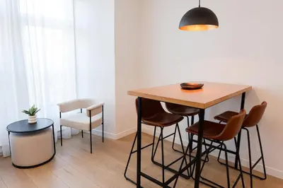 a kitchen with a wooden table and stools at #5 - Spacious 3Bds - Self Check in - Plateau - St-Denis - AC - TV in Montréal