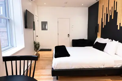 a bedroom with a white bed and a black wall at #6 - Artistic Studio - Self Check in - Plateau - St-Denis - AC - TV in Montréal