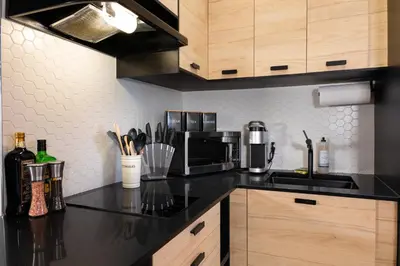 a kitchen with a black counter top and a microwave at #6 - Artistic Studio - Self Check in - Plateau - St-Denis - AC - TV in Montréal