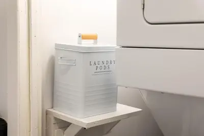 a white trash can sitting on a shelf next to a refrigerator at #6 - Artistic Studio - Self Check in - Plateau - St-Denis - AC - TV in Montréal