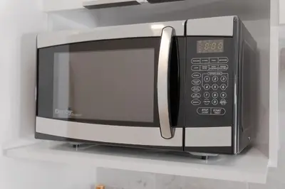 a microwave oven on a shelf in a kitchen at #7 - Charming Studio - Self Check in - Plateau - St-Denis - AC - TV in Montréal