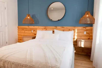a bedroom with a white bed with a blue wall at #7 - Charming Studio - Self Check in - Plateau - St-Denis - AC - TV in Montréal