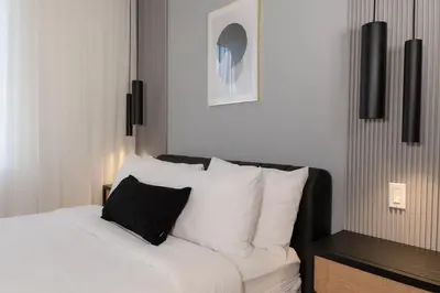 a bedroom with a bed with white sheets and black pillows at #8 - Refined Studio - Self Check in - Plateau - St-Denis - AC - TV in Montréal