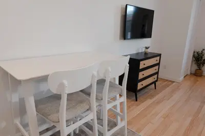 a white table and two stools in a room at #8 - Refined Studio - Self Check in - Plateau - St-Denis - AC - TV in Montréal