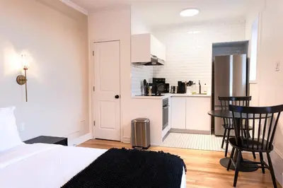 a bedroom with a bed and a small kitchen at #9 - Classic Studio - Self Check in - Plateau - St-Denis - AC - TV in Montréal