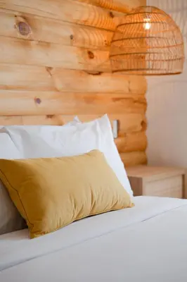 a bed with a yellow pillow and a wooden wall at #10 - Serene Studio - Self Check in - Plateau - St-Denis - AC - TV in Montréal
