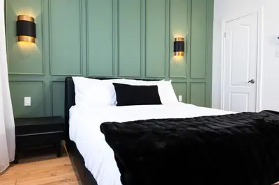a bedroom with a bed with white sheets and green walls at #11 - Upscale Studio - Self Check in - Plateau - St-Denis - AC - TV in Montréal