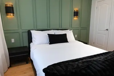 a large white bed with a black pillow on it at #11 - Upscale Studio - Self Check in - Plateau - St-Denis - AC - TV in Montréal