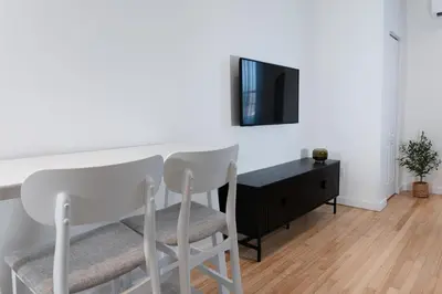 a living room with a table and two white chairs at #11 - Upscale Studio - Self Check in - Plateau - St-Denis - AC - TV in Montréal