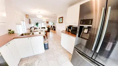 a kitchen with white cabinets and a stainless steel refrigerator at Condo de charme familial in Brossard