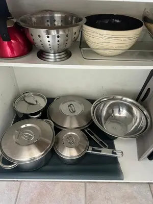a shelf filled with pots and pans and bowls at Condo de charme familial in Brossard