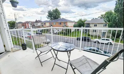 a patio with a table and chairs on a balcony at Condo de charme familial in Brossard