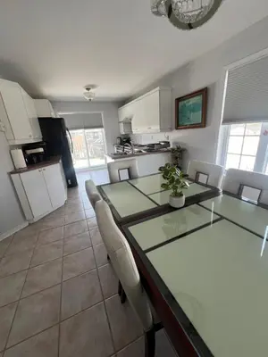 a kitchen and dining room with a glass table and chairs at Condo de charme familial in Brossard