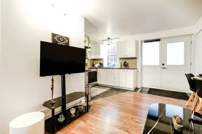 a living room with a flat screen tv on a wall at Charmant appartement de 2 chambres à Griffintown in Montréal