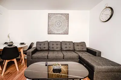 a living room with a couch and a table and a clock at Charmant appartement de 2 chambres à Griffintown in Montréal