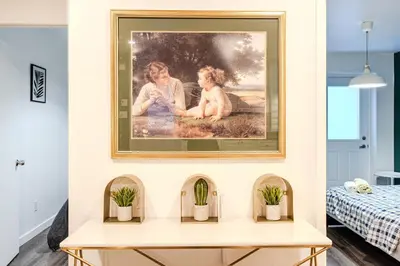 a painting on a wall above a table with plants at Cozy 2-Bedroom in Griffintown in Montréal
