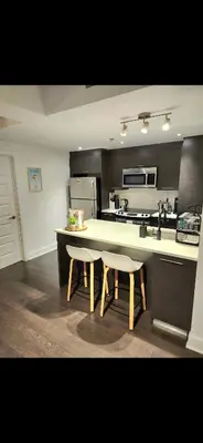 a kitchen with a table and two chairs and a sink at Condo 2 chambres avec parking privé - Griffintown in Montréal