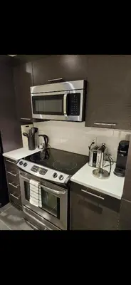 a kitchen with a stove and a microwave at Condo 2 chambres avec parking privé - Griffintown in Montréal