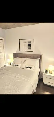 a bedroom with a large bed with white sheets and pillows at Condo 2 chambres avec parking privé - Griffintown in Montréal