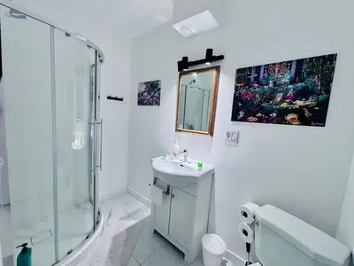 a white bathroom with a shower and a sink at Small but Equipped Unit in Montréal
