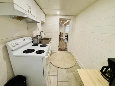 a small kitchen with a stove and a hallway at Opulent Studio - Semi Basement in Montréal