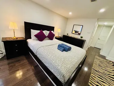 a bedroom with a large bed with purple pillows at Opulent Studio - Semi Basement in Montréal