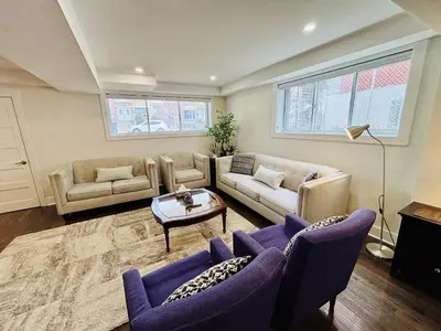 a living room with two couches and a table at Opulent Studio - Semi Basement in Montréal
