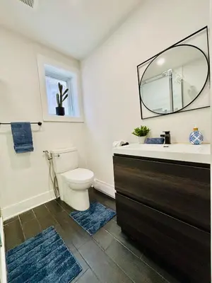 a bathroom with a toilet and a sink and a mirror at Opulent Studio - Semi Basement in Montréal