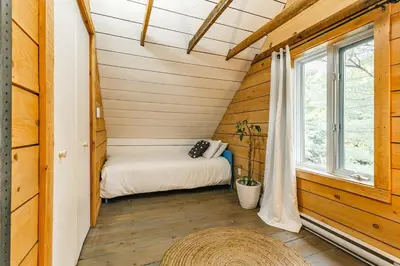 a small room with a bed and a window at Le 10 - Spa Sauna Shower Bromont Lac-Brome in Bromont