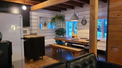 a kitchen and dining room with a wooden table at Le 10 - Spa Sauna Shower Bromont Lac-Brome in Bromont