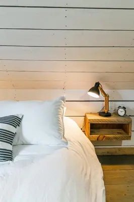 a bed with white sheets and a lamp on a table at Le 10 - Spa Sauna Shower Bromont Lac-Brome in Bromont