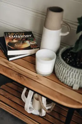 a coffee table with a book a candle and a vase at Chalet Chti - bord de l'eau mont Orford in Eastman