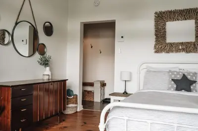 a bedroom with a bed and a mirror and a dresser at Chalet Chti - bord de l'eau mont Orford in Eastman