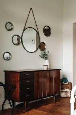 a mirror on a wall above a wooden dresser at Chalet Chti - bord de l'eau mont Orford in Eastman