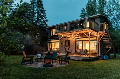 a tiny house with a fireplace in the yard at Chalet Chti - bord de l'eau mont Orford in Eastman