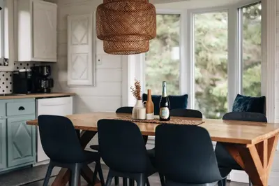 a kitchen with a wooden table and chairs at Chalet Chti - bord de l'eau mont Orford in Eastman