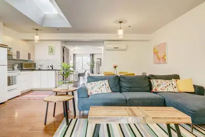 a living room with a blue couch and a kitchen at Spacious Group Haven Near Trendy St Laurent in Montréal