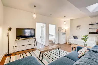 a living room with a blue couch and a tv at Spacious Group Haven Near Trendy St Laurent in Montréal