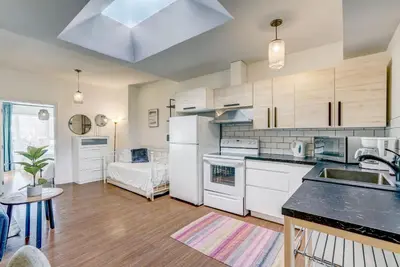 a kitchen with white appliances and a living room at Spacious Group Haven Near Trendy St Laurent in Montréal