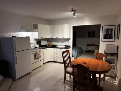 a kitchen with a table and a kitchen with a refrigerator at Le Globe Trotteur in Trois-Rivières
