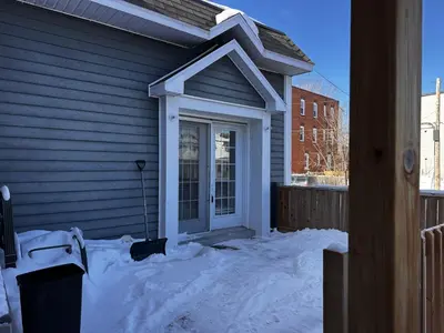 a front door of a house in the snow at Le Globe Trotteur in Trois-Rivières
