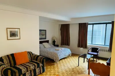 a living room with a couch and a bed at Stylish Montreal Apartment Comfortable Stay in the Golden Square Mile in Montréal