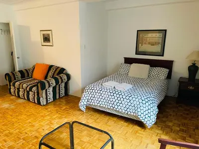 a living room with a bed and a couch at Stylish Montreal Apartment Comfortable Stay in the Golden Square Mile in Montréal