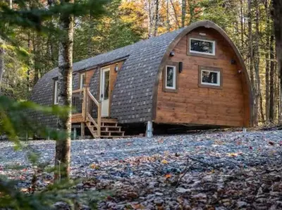 a large wooden cabin in the woods at Le POD du Mont ADSTOCK spa ski motoneige VTT plein air arcade in Adstock