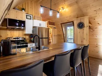 a kitchen with a large wooden counter top in a cabin at Le POD du Mont ADSTOCK spa ski motoneige VTT plein air arcade in Adstock