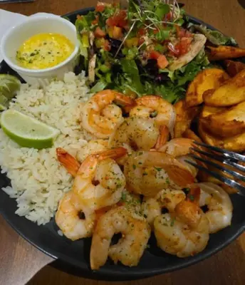 a plate of shrimp and rice with a salad and a fork at Le POD du Mont ADSTOCK spa ski motoneige VTT plein air arcade in Adstock