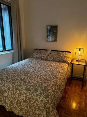 a bedroom with a bed and a lamp on a table at Fully furnished 2 bedroom unit, downtown, near subway, 32 days minimum in Montréal