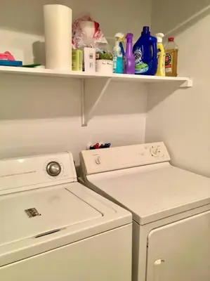 a laundry room with a washing machine and a shelf at Fully furnished 2 bedroom unit, downtown, near subway, 32 days minimum in Montréal
